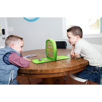 Two children playing with Elf Match Crazy Cube Game festive board game at a wooden table.