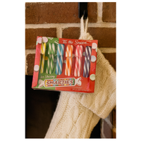 Pack of Smarties candy sticks in front of a brick wall