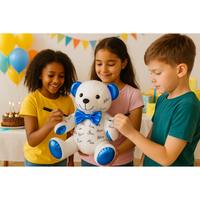 Three children writing on a white teddy bear with blue accents at a birthday party.
