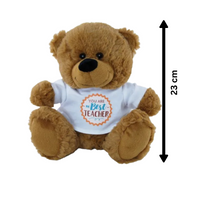 Brown teddy bear wearing a white shirt with text, with a measurement label indicating its height.
