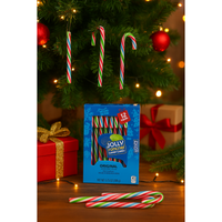 Jolly Rancher candy canes in front of a Christmas tree with packaging.
