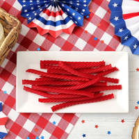 Redvines Original Red candy sticks on a white plate with American flag decorations in the background
